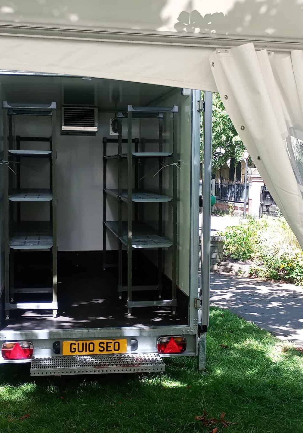 Inside view of a Cold Space fridge trailer with shelving units.